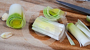 Preparing Fresh Leeks and Garlic on a Wooden Cutting Board for Cooking