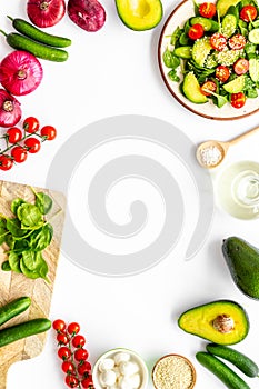 Preparing fresh salad. Vegetables, greens, spices on white background top view copy space frame