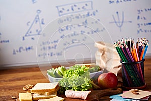 Preparing ham sandwiches for school lunchbox on wooden background, close up.