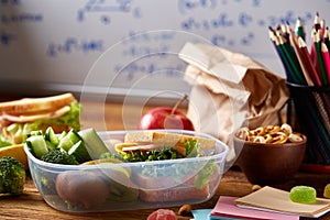 Preparing ham sandwiches for school lunchbox on wooden background, close up.