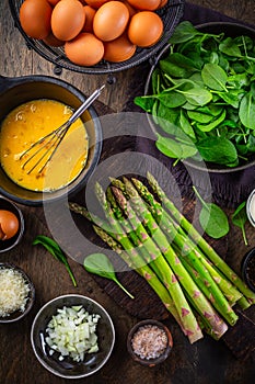 Preparing healthy asparagus and spinach omelet or frittata with ingredients photo