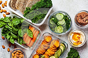 Preparing healthy food for the week, top view. Vegan food and healthy snacks in containers, gray background