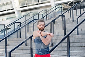 Preparing his muscles. Fitness man warming up in the gym. Having a good stretch. Handsome man in sports clothing