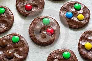 Preparing homemade chocolate cookies decorated with colored candy drops