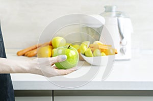 Preparing homemade fresh juice made with apples, oranges and carrots.