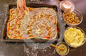 Preparing homemade pizza with cheese,salami and mushrooms