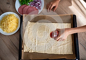 Preparing ingrediants to make pizza at home focus on hand