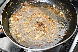 preparing the last step of the popular Egyptian Molokhiya soup making Taqliya Takliya which is frying minced garlic in ghee with