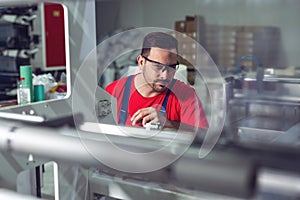 Preparing machine for printing. Maintenance engineer repair modern industrial machine.