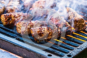 Preparing meat rolls called mici or mititei on barbecue. close up of grill with burning fire with flame and smoke