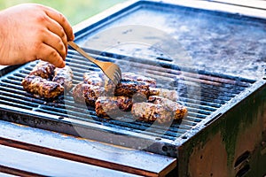 Preparing meat rolls called mici or mititei on barbecue. close up of grill with burning fire with flame and smoke