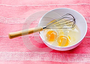 Preparing omelet with eggs and whisk