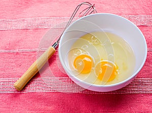 Preparing omelet with eggs and whisk