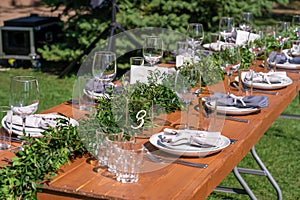 Preparing for an open-air party. Decorated with fresh flowers served tables. Table number. Decoration Details