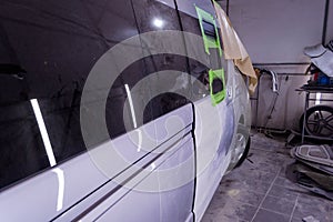 Preparing for painting a silver bus in a body repair shop in a s
