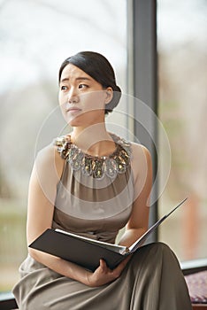 Preparing for the performance. an elegantly dressed young woman reading through a folder.