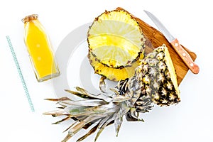 Preparing pineapple juice. Cut slices of pineapple with a knife on white background top view