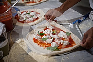 Preparazione una grande sfoglia circolare di pasta leggera sul pizzerie 