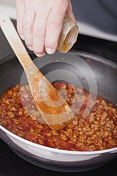 Preparing sauce with meat for spaghetti with pork and beef, tomato and cheese