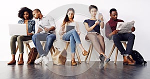 Preparing with some research. a group of diverse businesspeople waiting in line for an interview.