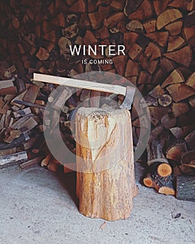 Preparing and splitting wood with an axe for winter, with text: winter is coming, ilustrative photo