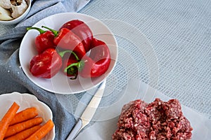 Preparing  stuffed red peppers with minced meat, rice and vegetables