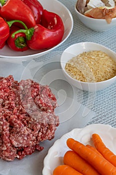 Preparing  stuffed red peppers with minced meat, rice and vegetables