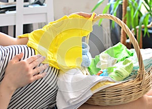 Preparing to be a mother concept. Pregnant woman packing bag for maternity hospital at home.