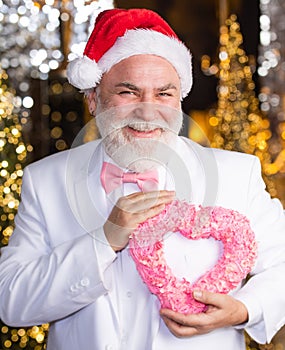 Preparing to Christmas. he loves xmas holidays. this winter may be joyful. senior santa in tuxedo at christmas lights