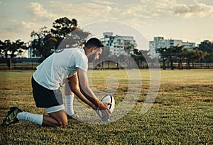 Preparing to take the big kick. Full length shot of a handsome young rugby player preparing for a kick while training on