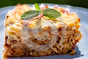 Preparing traditional greek food recipe. Baked pasta casserole pastitsio with rich bechamel sauce and ground beef