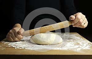 Woman hands kneading fresh dough for making bread or pizza.