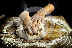 Woman hands kneading fresh dough for making bread or pizza.