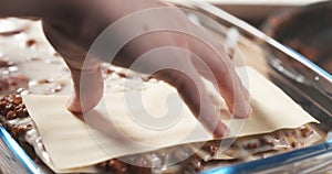 Preparing traditional italian lasagna adding pasta