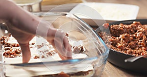 Preparing traditional italian lasagna adding pasta