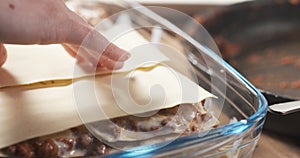 Preparing traditional italian lasagna adding pasta