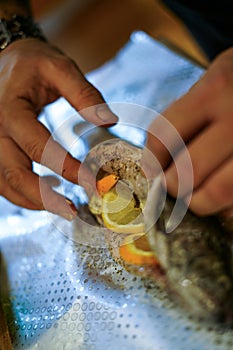 Preparing trouts with lemons, butter and fresh dill.
