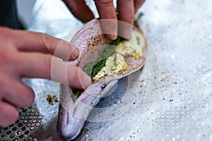 Preparing trouts with lemons, butter and fresh dill.