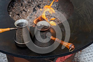 Preparing Turkish coffee with black cezve or ibrik at street food festival photo