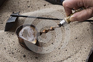 Preparing of Turkish coffee in cezve (turkish pot) on the hot sand