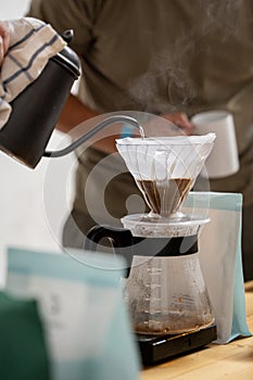 Preparing V60 coffee, pouring hot water over coffee photo
