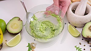 Preparing vegetarian avocado sauce - Mashing avocado in bowl with a spoon