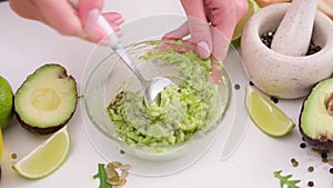 Preparing vegetarian avocado sauce - Mashing avocado in bowl with a spoon