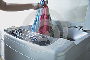 Preparing the wash cycle. Washing machine, Hand with clothes