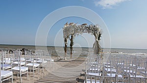 Preparing for a wedding ceremony on the beach. Wooden wedding arch decorated with floral arrangements.