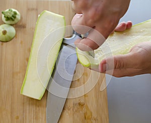 Preparing zuchini hands on the kitchen table close up