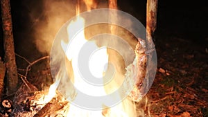 A prepper cooks food on an open fire.