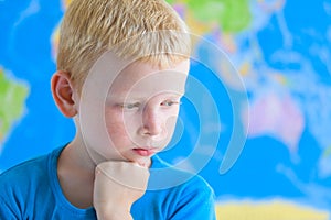 Preschool boy dreaming in front of world map