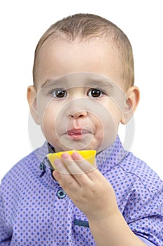 Preschool boy eating sour lemon