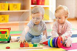 Preschool boy and girl playing on floor with educational toys. Children at home or daycare. photo